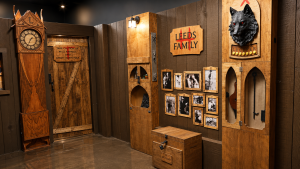 Rustic cabin escape room with weathered doors, Leeds family photos and a mounted animal head at Exit 4 Chandler